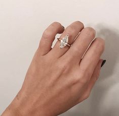 a woman's hand with a ring on top of her finger and a diamond in the middle