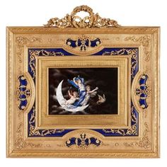 an ornate gold frame with a blue and white painting on it