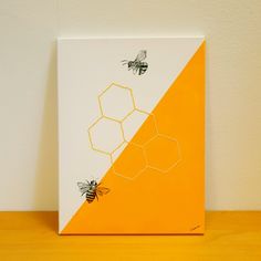 two bees on a yellow and white painting with orange border around the beehive