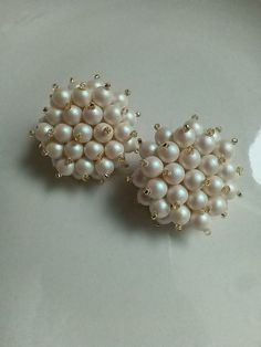 These earrings are large, slightly larger than a quarter. Glass pearls are clustered together for an elegant and timeless look. the pearlescent coating gives the look of a classic pearl with a slighly pinkish hue  Gold-plated post and a leather backing is used for comfort and a monster ear-nut is used for support. Pearl Earrings For Evening, Elegant Round Bead Clip-on Earrings For Party, White Pearl Clip-on Earrings With Pearl Charm, White Pearl Drop Clip-on Earrings For Party, Elegant Party Clip-on Earrings With Round Beads, White Pearl Embellished Earrings For Party, White Pearl Charm Bridal Earrings For Evening, White Bridal Earrings With Pearl Charm For Evening, White Pearl Charm Earrings For Evening