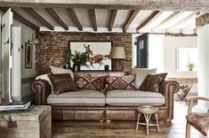 a living room filled with furniture next to a brick wall