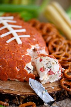 a football shaped pizza on top of a cutting board