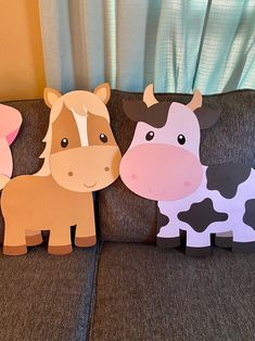 three paper farm animals sitting on top of a couch