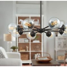 a large chandelier with glass balls hanging from it's centerpiece in a living room