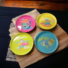 four plates with cartoon characters on them sitting on a napkin