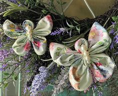 an image of a wreath with flowers and ribbons hanging on the front door ornament