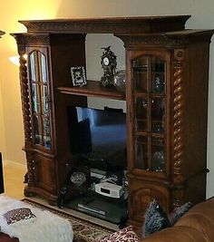 a living room with a couch, television and entertainment center in it's corner