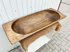 an old wooden bath tub sitting on top of a table