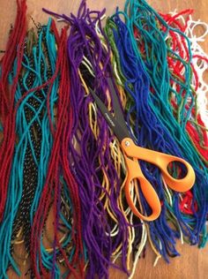 several pairs of scissors are sitting on a table covered with colorful cords and threading