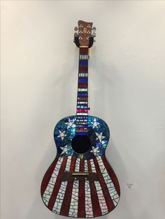 a stained glass guitar hanging on the wall