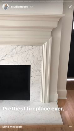 the fireplace is white and has a black screen on it