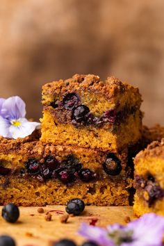 blueberry coffee cake is stacked on top of each other, with flowers in the background