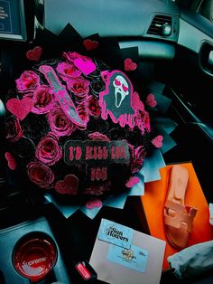 a car decorated with pink and black roses in the passenger side mirror, next to other items