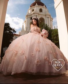 a woman in a pink ball gown is posing for a photo with her hand on her hip