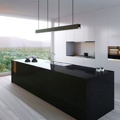 a modern kitchen with black counter tops and white cabinets, along with an island in the middle