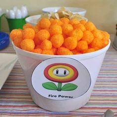 a bucket filled with orange cheetos sitting on top of a table