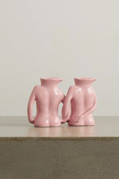 two pink vases sitting on top of a table