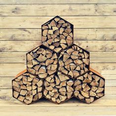 a stack of logs sitting on top of a wooden floor next to a wall covered in wood