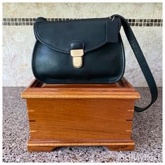 a black purse sitting on top of a wooden box