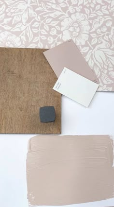 some paint samples are sitting on top of a wooden board with a gray and white color scheme