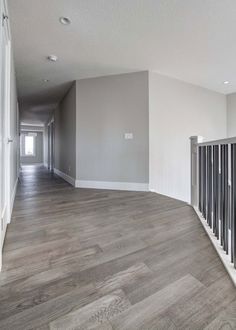 an empty room with wood floors and white walls