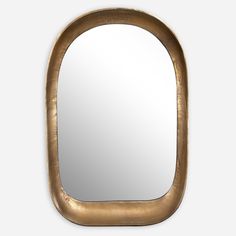 an oval mirror with a gold frame