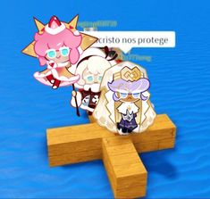 two paper dolls sitting on top of a wooden cross in the middle of blue water