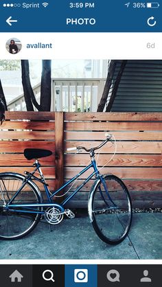 a blue bike parked next to a wooden fence