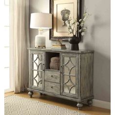 an antique style cabinet with mirrored doors and drawers in front of a large mirror on the wall