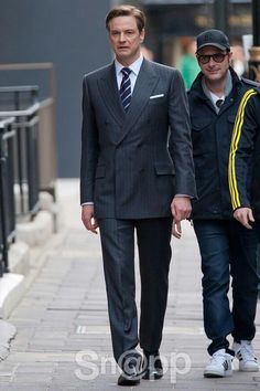 two men in suits walking down the street