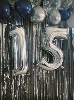 balloons and streamers are arranged in the shape of the letter s on a silver background