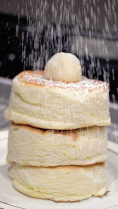 a stack of pancakes covered in powdered sugar