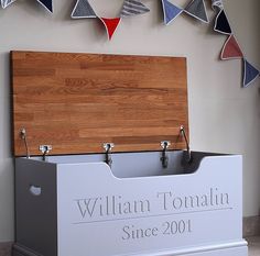 a large wooden cutting board on top of a white box next to a sign that says william tomalin since 2011