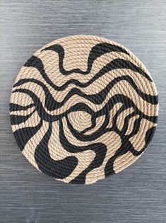 a black and white plate sitting on top of a wooden table next to a wall