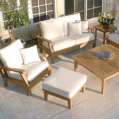 an outdoor living area with white furniture and flowers