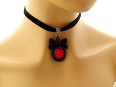 "Gothic choker Goth necklace Gothic jewelry Goth jewelry Gift for her Red Rose Black Cameo Necklace on Black Velvet choker Matching ring Gothic red rose cameo on a black background, set in a black acrylic bow tie topped frame. The cameo hangs from a velvet choker with a silver toned extender chain adjustable from 12.5 to 14.25 inches Cameo pendant - 2 inches Velvet choker necklace: 12.5-14.24 inches Arrives with a Marty White card in a lovely decorative bag and bubble wrap packaging. Facebook: h Gothic Adjustable Round Necklace, Gothic Round Adjustable Necklace, Emo Choker Necklaces For Valentine's Day, Emo Choker Necklace For Valentine's Day, Emo Necklace For Valentine's Day Gift, Emo Style Necklace For Valentine's Day Gift, Emo Valentine's Day Choker Necklace, Valentine's Day Emo Choker Necklace, Adjustable Red Gothic Jewelry