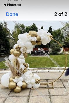 the balloon arch is decorated with gold and white balloons