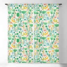 a window curtain with cactus print on the outside and green leaves on the inside, in front of a white wall