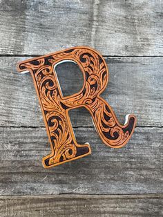 the letter p is made out of wood and has an intricate design on it's side