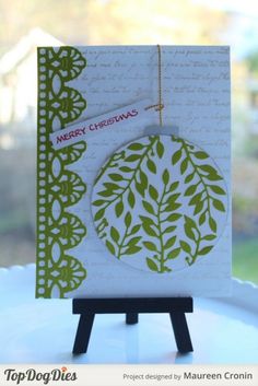 a close up of a greeting card on a table with a white background and green leaves