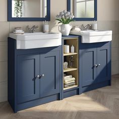 a bathroom with two sinks and blue cabinets