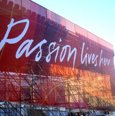 a large advertisement on the side of a building that says passion live music festival in front of it