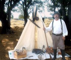 a man standing in front of a teepee tent with tools on the ground next to it