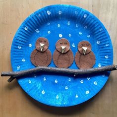 three little birds sitting on top of a blue paper plate