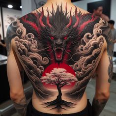 the back of a man's body is covered in tattoos with an image of a dragon and a tree