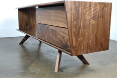 a wooden cabinet sitting on top of a cement floor