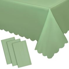 green tablecloth with scalloped edges and placemats on white background for display