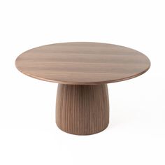 a round wooden table sitting on top of a white floor