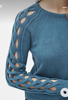 a woman wearing a blue sweater with cut out sleeves