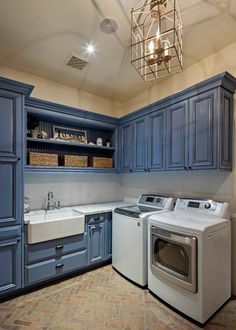 a washer and dryer in a room with blue cabinets